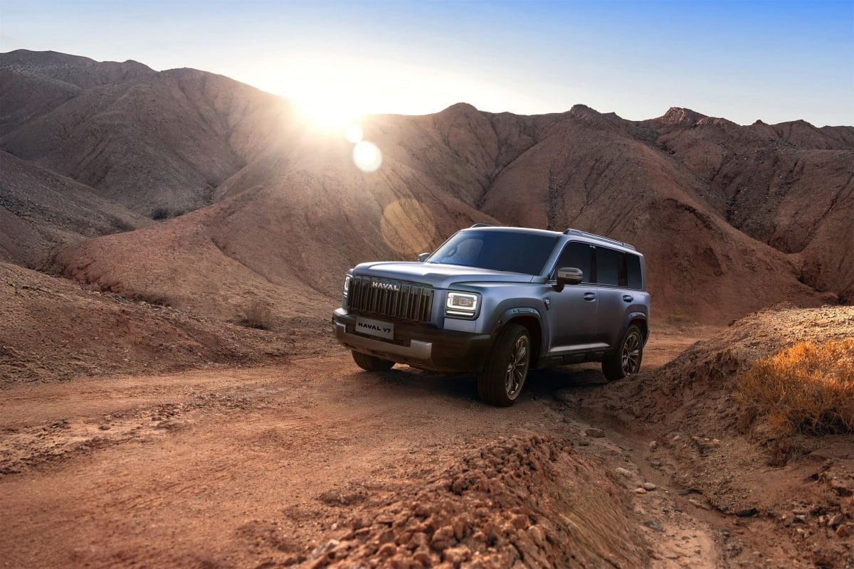 Silver Haval V7 SUV driving through rocky desert mountains during sunset, showcasing off-road capability in KSA terrain.