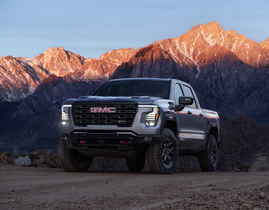2027 GMC Sierra AT4X off-road pickup against a mountain landscape